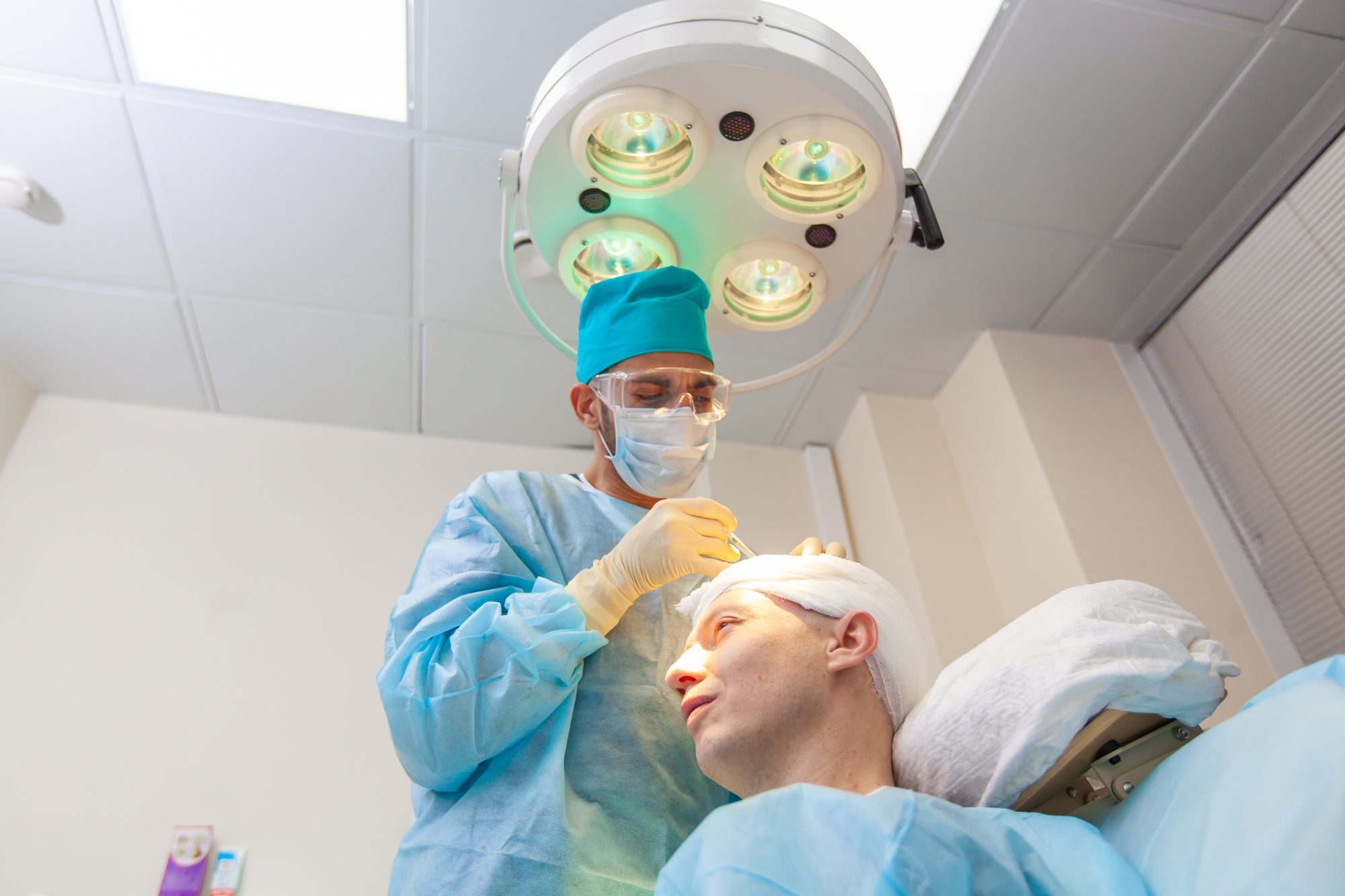 The surgeon gives injections to the head. Baldness treatment. Hair transplant. Surgeons in the operating room carry out hair transplant surgery. Surgical technique that moves hair follicles from a part of the head.